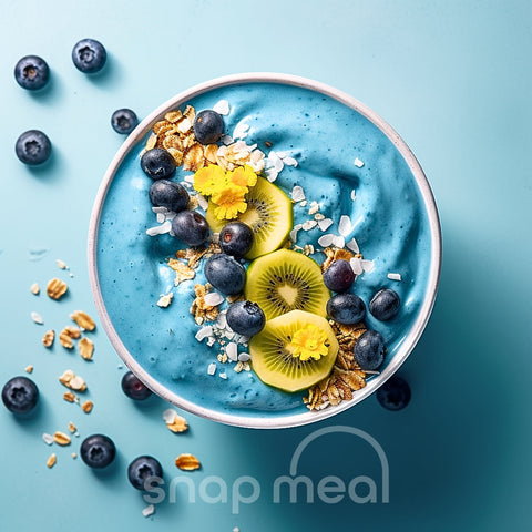 Verpakte kant-en-klare Blue Spirulina smoothie bowl, rijkelijk versierd met vers fruit en granen, ideaal om thuis direct te consumeren en klaar voor thuisbezorging